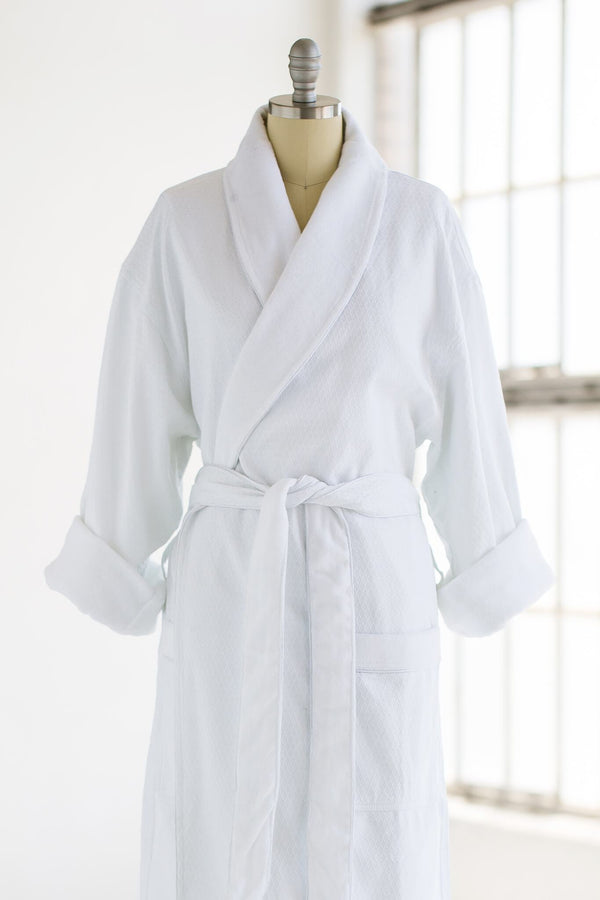 Close up of white, tall, terry cloth robe on mannequin with a white background.